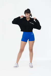 Black crop fleece hoodie styled with athleisure outfit indoors